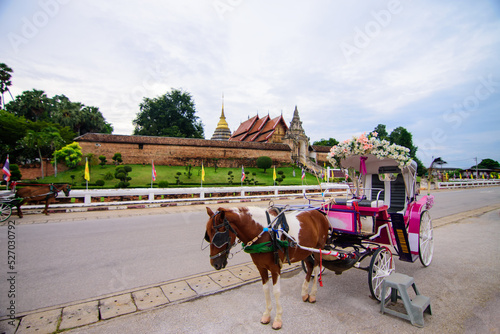 Ancient horse carriage waiting for tourists at Wat Phra That Lampang Luang, Lampang Province, Lampang, Thailand. photo
