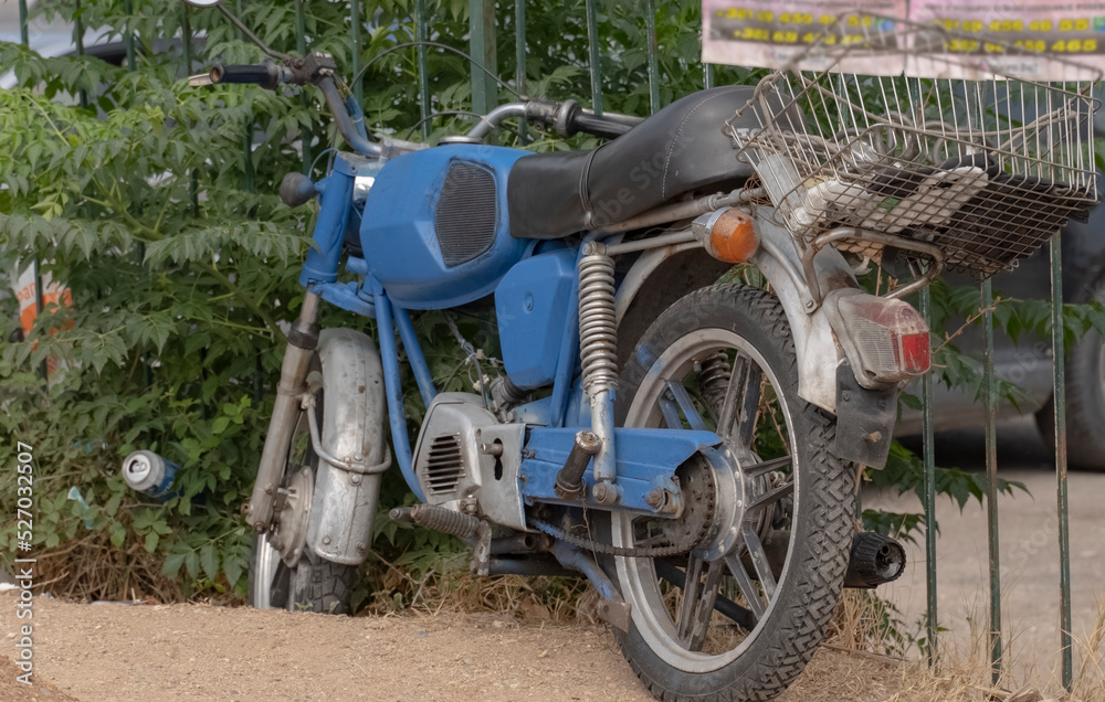 an old abandoned blue motorcycle forgotten by the owner on the street. Old vehicles. Soviet two-wheeled motorcycle.