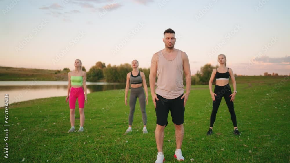 workout in park, free fitness training from group of women, athletic man is showing exercise workout in park, free fitness training from group of women, athletic man is showing exercise