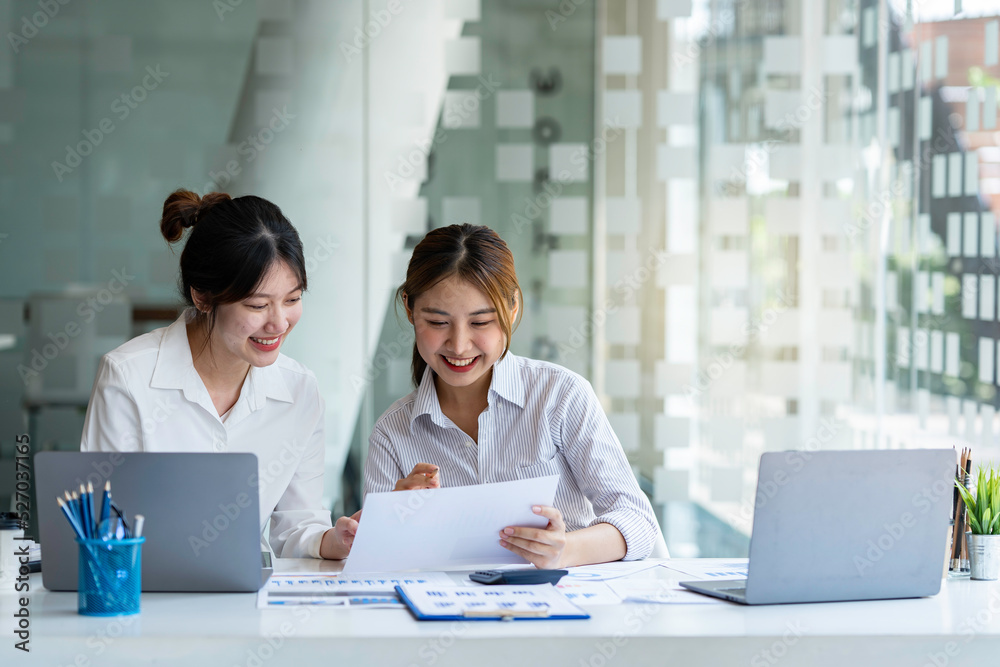 Two young female accountants in casual clothes working with laptops and discussing company investment results and profits and annual bonuses, finance ideas, and collaboration. Two young female accountants in casual clothes working with laptops and discussing company investment results and profits and annual bonuses, finance ideas, and collaboration.