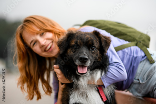 Close-up of happy smiling young woman hugging her shaggy dog