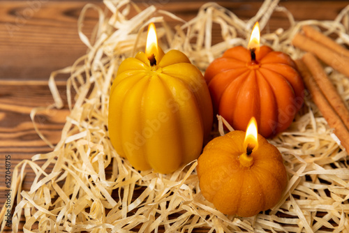 Autumn composition.Pumpkin candles on a brown wooden background.Cozy home decor.Halloween concept.Happy thanksgiving.Flat lay.Copy space.