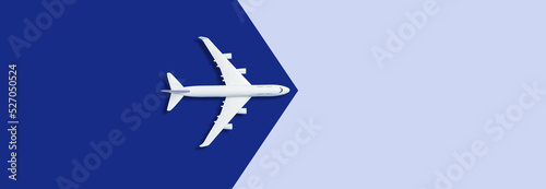 Flat lay of miniature toy airplane on blue background