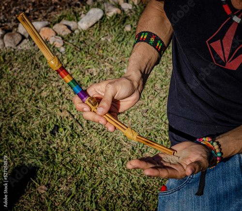 Sao Paulo, SP, Brazil - August 23 2021: Male hands holding tepi, instrument for application of indigenous snuff details.