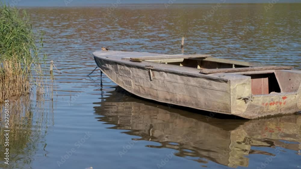 Old boat on the river bank. Fishing boats near the river bank. River landscape in the spring with wooden boats near the river bank. Old boat on the river bank. Fishing boats near the river bank. River landscape in the spring with wooden boats near the river bank.