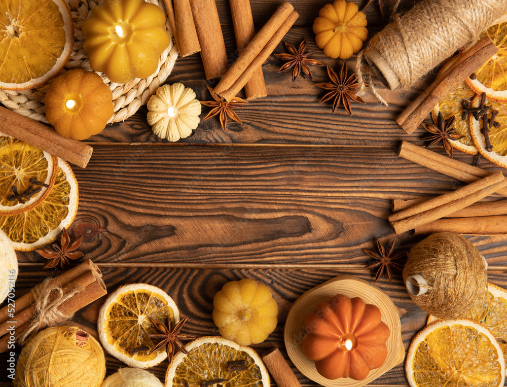 Autumn composition.Pumpkin candles,spicy star anise spices and cinnamon on a brown wooden background.Cozy home decor.Halloween concept.Happy Thanksgiving.Flat lay.Copy space.