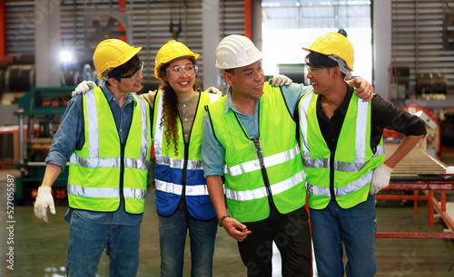 Portrait of a team of Asian male and female engineers in safety suits standing and talking. happy in the factory