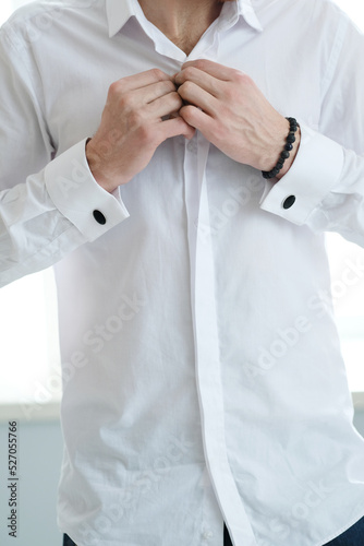 Man in a white shirt posing on white background in studio