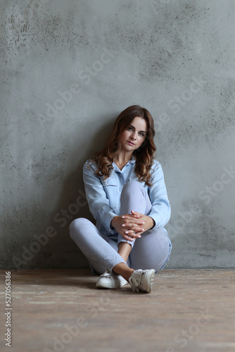 Chic and Confident: Woman Strikes a Pose on a Grey Studio Background, Embodying Modern Style and Elegance