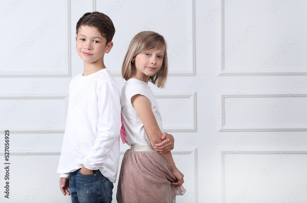 A girl and a boy sit in the studio and pose for a photo