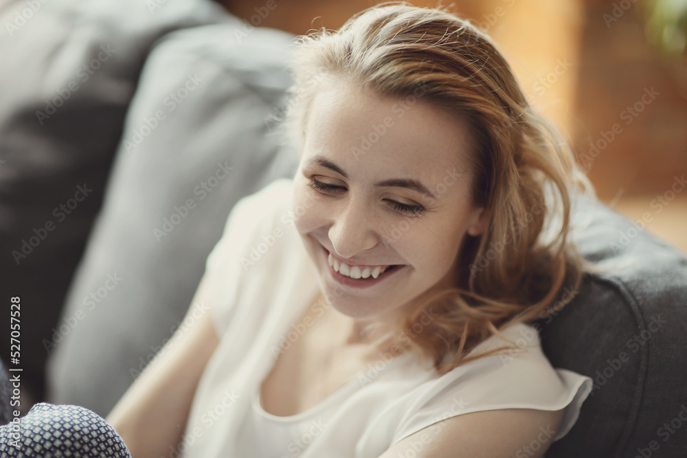 Fototapeta premium Blonde woman smiling at home taking photo for social media
