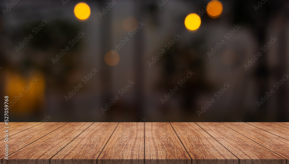 Empty wooden table top with lights bokeh on blur restaurant background.