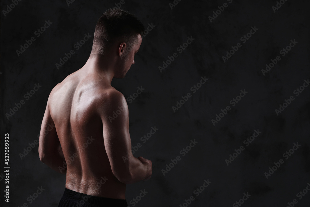 Fototapeta premium Sculpted to Perfection: Male Model Showcases His Fit Physique in a Studio Photoshoot