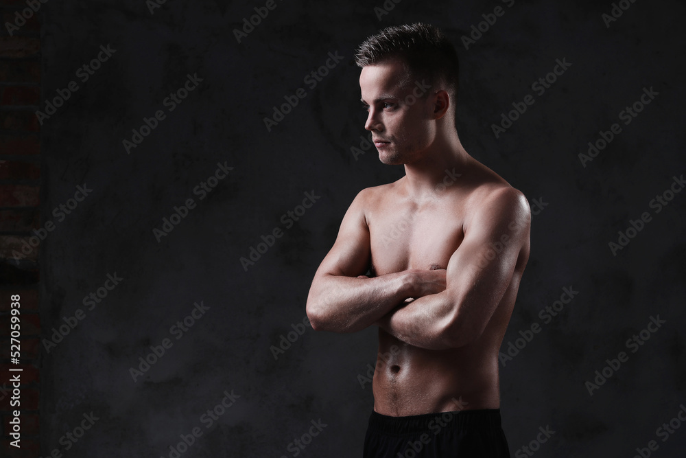 Fototapeta premium Sculpted to Perfection: Male Model Showcases His Fit Physique in a Studio Photoshoot
