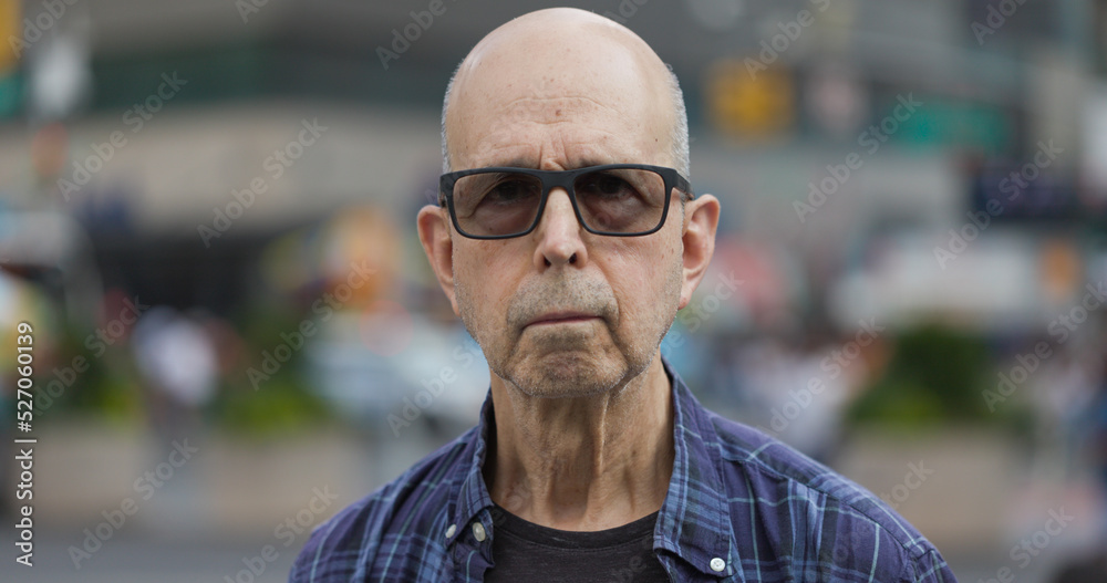 Mature caucasian man serious angry face portrait on a city street Mature caucasian man serious angry face portrait on a city street