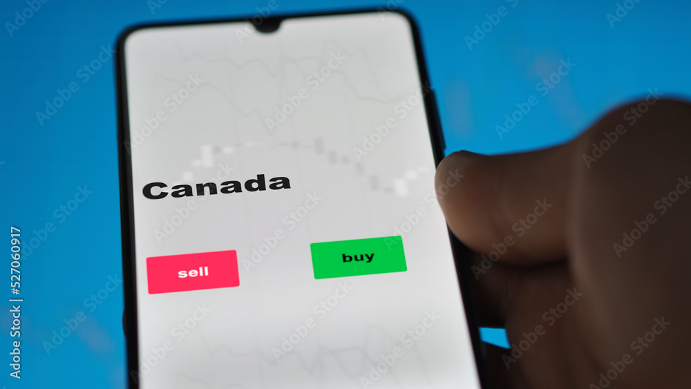 Naklejka premium Un investisseur analyse le fonds FNB Canada à l'écran. Un téléphone affiche les prix de l'ETF canadien canada canadien à investir, texte en anglais.
