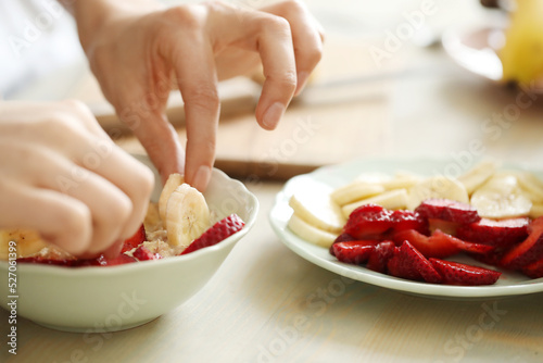 Preparing Fresh Strawberry and Banana Fruit Salad in a Bright Kitchen