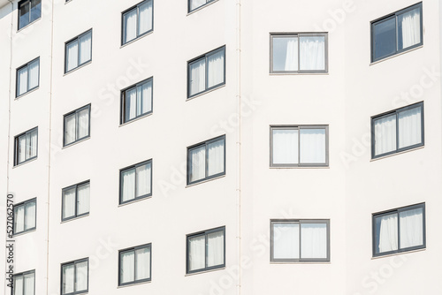 Close-up of the facade of a white building with windows.