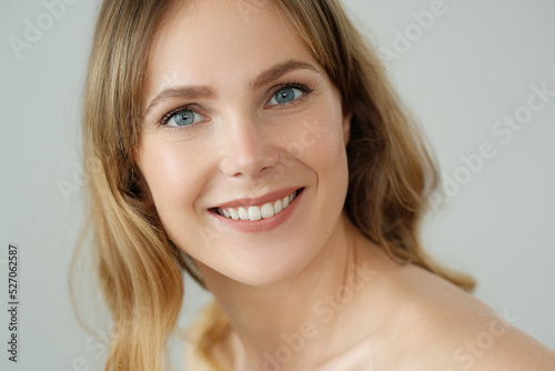 Close view of young blond woman with wide smile at home