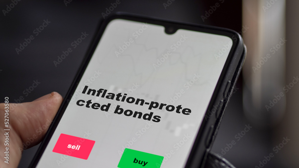 An investor's analyzing the inflation-protected bonds etf fund on screen. A phone shows the ETF's prices inflation protected bonds to invest An investor's analyzing the inflation-protected bonds etf fund on screen. A phone shows the ETF's prices inflation protected bonds to invest