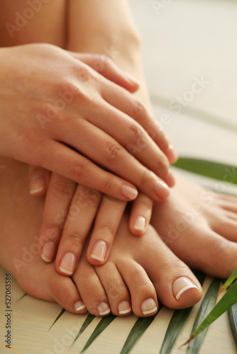 Perfect female hands with manicure on women   s legs 