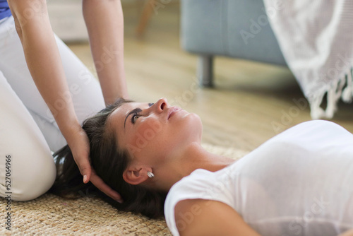 Professional massages young woman’s head on the floor