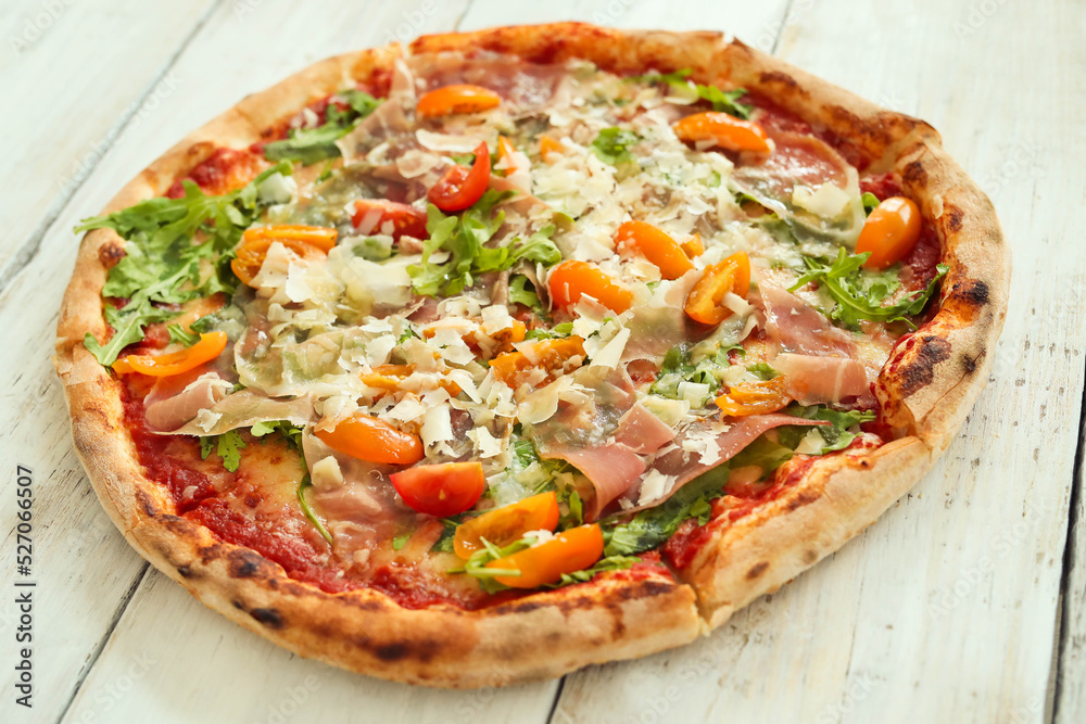 Picture of delicious hot whole pizza with vegetables on a wooden background