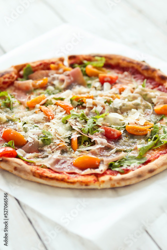 Close view of delicious hot whole pizza with vegetables 