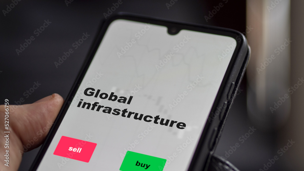 An investor's analyzing the stocks on screen. A phone shows the ETF's prices global infrastructure An investor's analyzing the stocks on screen. A phone shows the ETF's prices global infrastructure