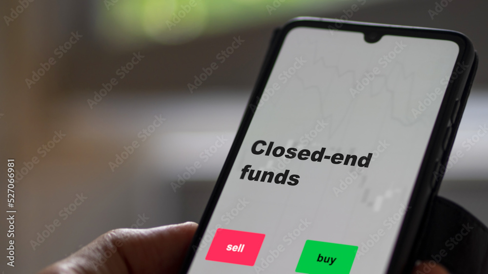 An investor's analyzing the stocks on screen. A phone shows the ETF's prices closed-end funds An investor's analyzing the stocks on screen. A phone shows the ETF's prices closed-end funds