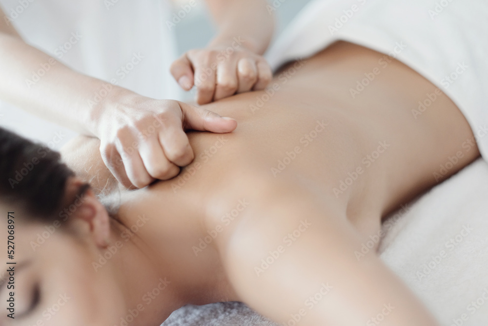 Women’s hands giving a relaxing massage to a beautiful young woman in the spa salon Women’s hands giving a relaxing massage to a beautiful young woman in the spa salon