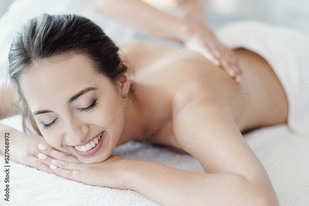 Women’s hands giving a relaxing massage to a beautiful young woman in the spa salon