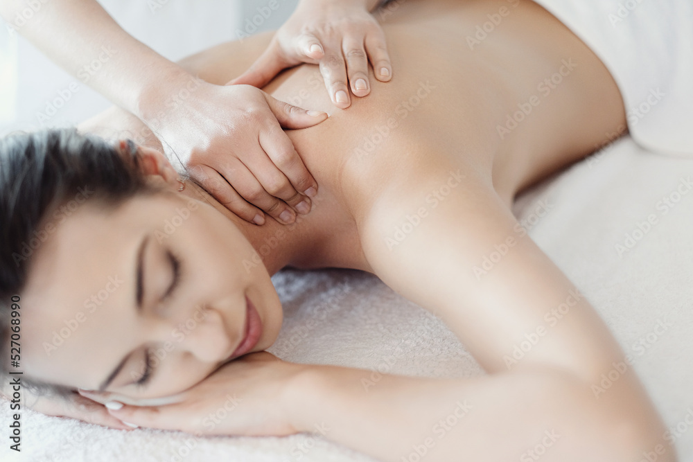Women’s hands giving a relaxing massage to a beautiful young woman in the spa salon Women’s hands giving a relaxing massage to a beautiful young woman in the spa salon