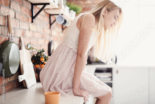 Photo of a young girl model posing in a beautiful dress in the kitchen