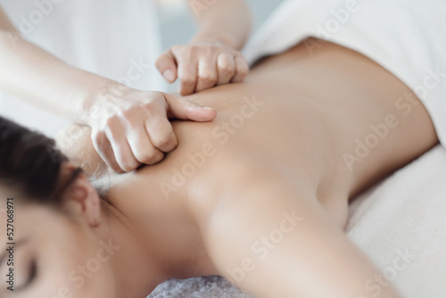 Women’s hands giving a relaxing massage to a beautiful young woman in the spa salon