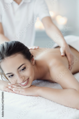 Women’s hands giving a relaxing massage to a beautiful young woman in the spa salon