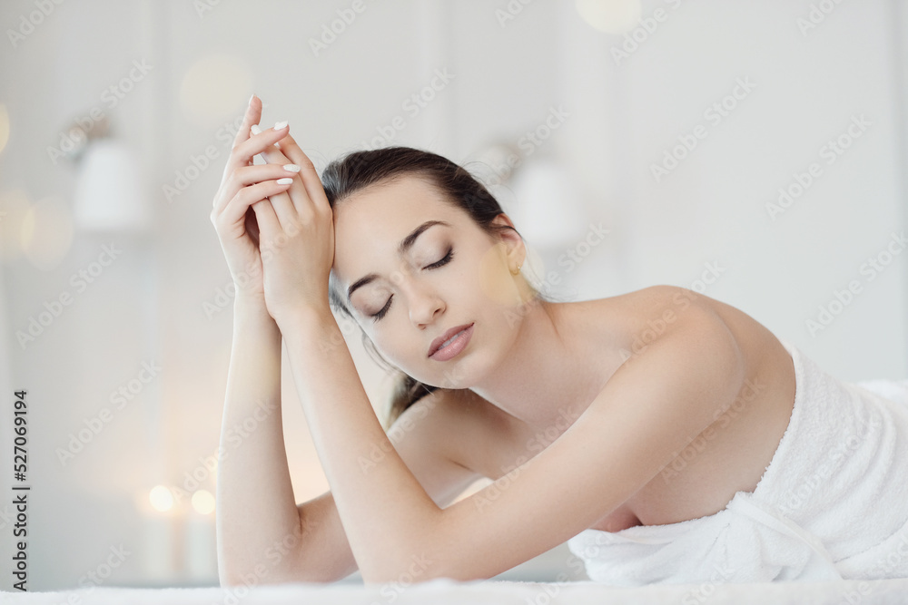 Relaxed beautiful young woman lying on the couch after massage in the spa Relaxed beautiful young woman lying on the couch after massage in the spa