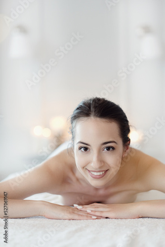 Relaxed beautiful young girl lying on the couch after massage in the spa
