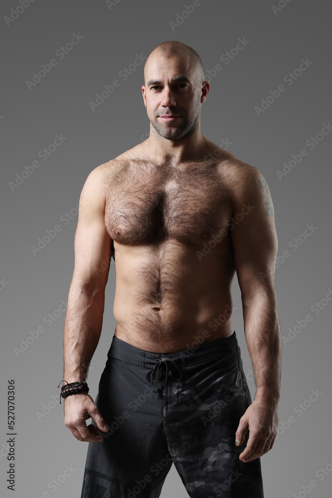 Portrait of a sporty, confident, muscular bodybuilder with a naked torso posing for camera Portrait of a sporty, confident, muscular bodybuilder with a naked torso posing for camera