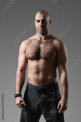 Portrait of a sporty  confident  muscular bodybuilder with a naked torso posing for camera