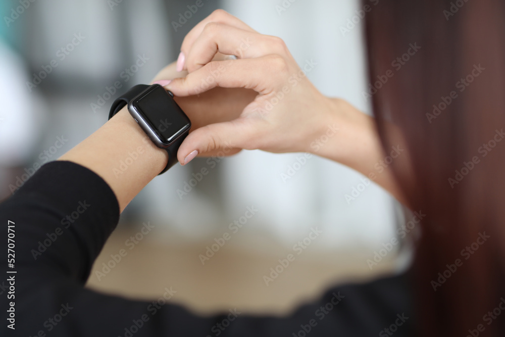 Women hands checking her smart watch