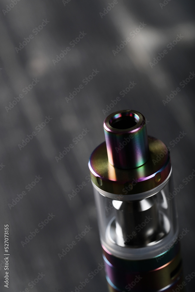 An electronic cigarette for smoking nicotine on a dark wooden background An electronic cigarette for smoking nicotine on a dark wooden background