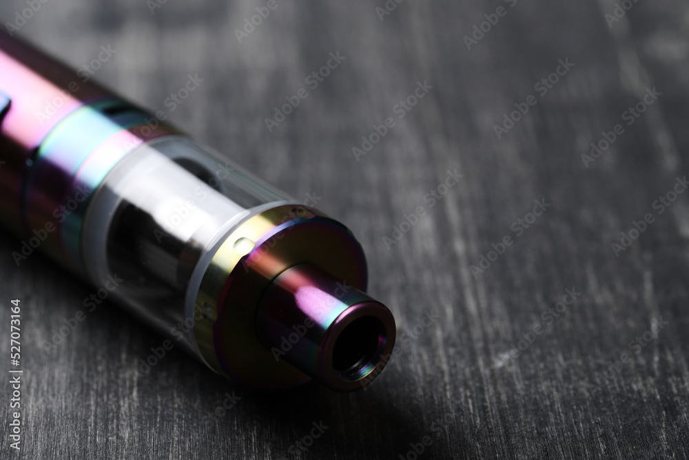 An electronic cigarette for smoking nicotine on a dark wooden background