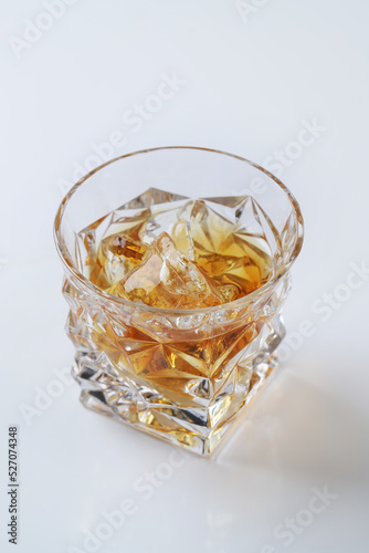 Top view of whiskey with ice or brandy in a glass on a white background.