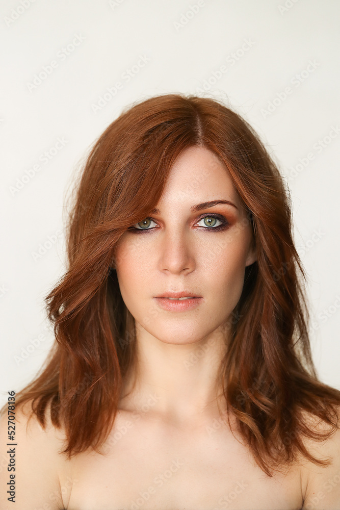 Close-up photo of a beautiful redheaded woman looking at the camera on a marble background Close-up photo of a beautiful redheaded woman looking at the camera on a marble background