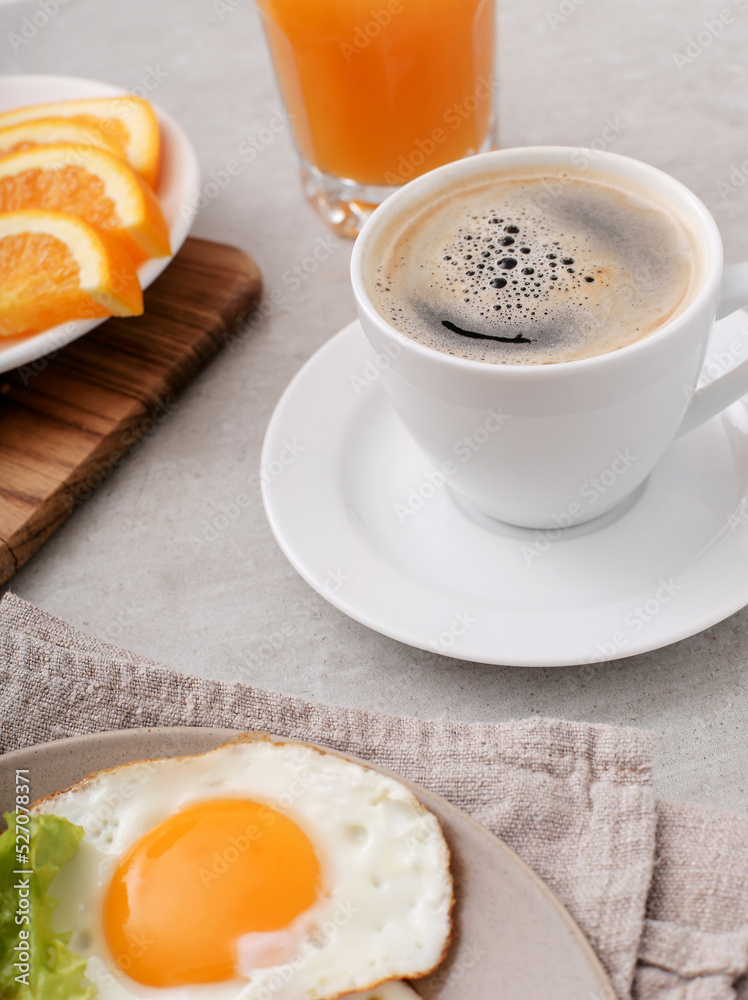 Fototapeta premium Morning breakfast with fried eggs,orange juice and a cup of coffee on a marble background