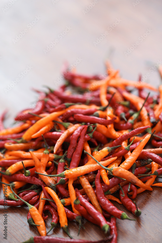 Fresh juicy red and yellow hot chili peppers isolated on a wooden background. Fresh juicy red and yellow hot chili peppers isolated on a wooden background.