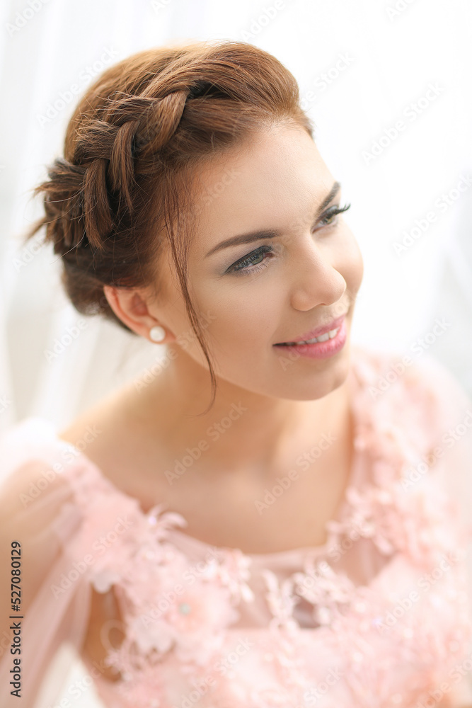 Close-up portrait of a young,smiling woman in beautiful,pink dress looking away