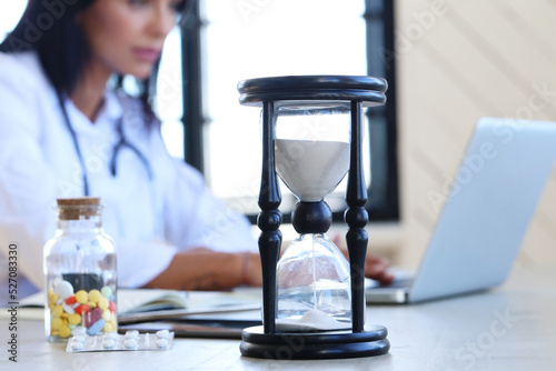 Confident, professional female-doctor sitting and working with medication history record forms at doctor's office