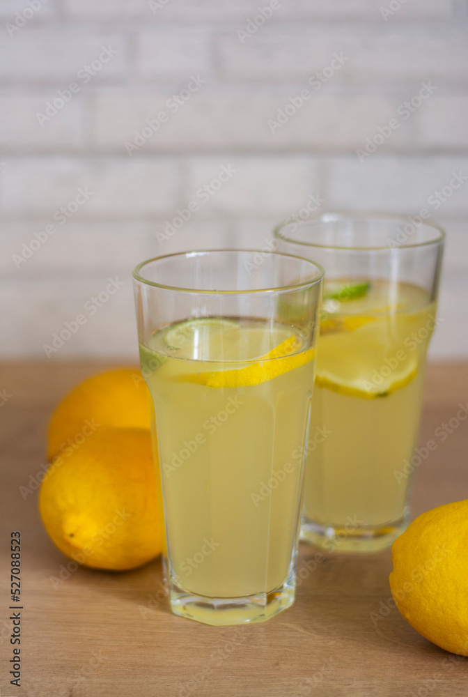 Two mason jar glasses of homemade lemonade on in bright kitchen. Fresh homemade tasty lemonade cold refreshing drink or beverage with ice Two mason jar glasses of homemade lemonade on in bright kitchen. Fresh homemade tasty lemonade cold refreshing drink or beverage with ice